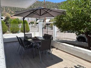 a table and chairs with an umbrella on a deck at Elena's House in Methana