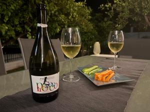a bottle of wine and two glasses on a table at Elena's House in Methana +9 photos