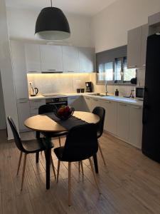 a kitchen with a table and chairs and a kitchen with white cabinets at Elena's House in Methana