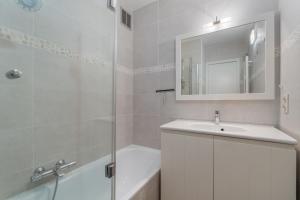 a white bathroom with a sink and a mirror at Parkhouse C0 in De Haan +8 photos