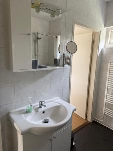 a bathroom with a white sink and a mirror at huize Louwra in Egmond-Binnen +34 photos