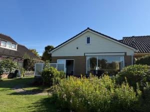 a house with a large window in a yard at huize Louwra in Egmond-Binnen