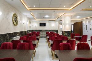 una sala conferenze con sedie e tavoli rossi di Hotel Opera a Rouiba