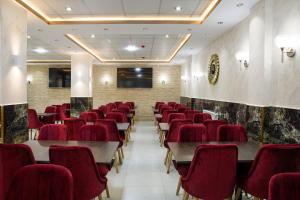 una sala conferenze con tavoli e sedie rosse di Hotel Opera a Rouiba