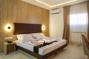 una camera da letto con un grande letto in una stanza di Hotel Opera a Rouiba