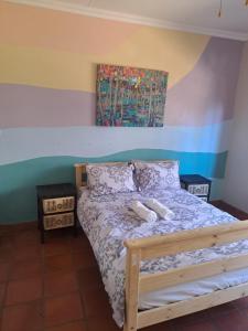 a bedroom with a bed and a painting on the wall at Wakanda on Hartbeespoort Dam in Hartbeespoort