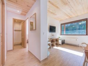 a living room with white walls and a wooden ceiling at Résidence Le Relax - Megève Centre in Megève