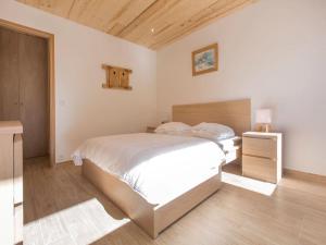 a bedroom with a white bed and a wooden floor at Résidence Le Relax - Megève Centre in Megève