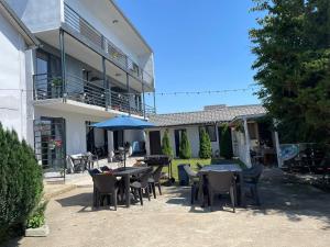 a patio with tables and chairs in front of a building at Vila B&P in Costinesti