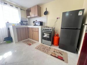 a kitchen with a stove and a refrigerator at Gracious homes in Narok