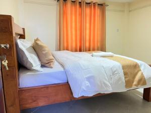 a bed with white sheets and pillows in a bedroom at Gracious homes in Narok