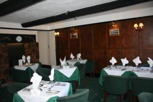 a dining room with tables and chairs with napkins at Yarn Market Hotel in Dunster