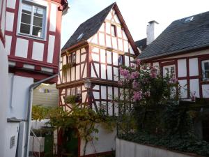 ein altes Gebäude mit rosa Blumen davor in der Unterkunft B&B Briedel in Briedel