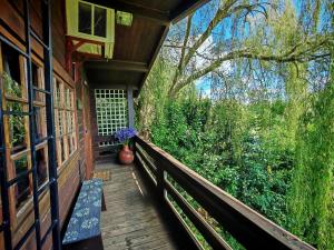 a porch of a house with a vase of flowers at Tegwaan's Nest B&B in Mooiriver