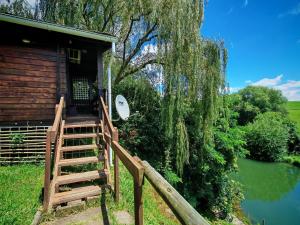 a wooden cabin with a staircase leading to the door at Tegwaan's Nest B&B in Mooiriver