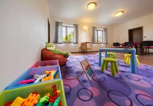 a play room with a table and toys in it at Penzion Mušlov in Mikulov