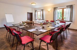 a meeting room with tables and red chairs at Penzion Mušlov in Mikulov