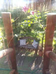 a wooden bench in a garden with a plant at Pedral Beach chalé e restaurante in Parnaíba