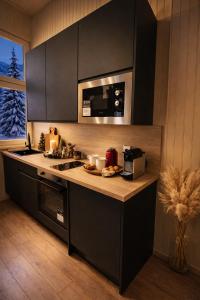 a kitchen with a counter top with a stove and a microwave at Ma Montagne Chic 4 in La Bresse