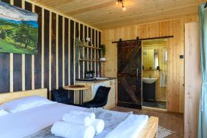 ein Schlafzimmer mit Bett und ein Badezimmer mit Waschbecken in der Unterkunft Colnic Tiny House in Măgura