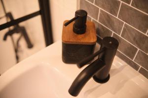 a wooden soap dispenser sitting on top of a sink at 2 Bedroom House By Travel Lets Holiday Homes Derry With Garden in Derry Londonderry +49 photos