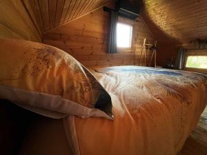 a bed in a log cabin with a window at Cottage relaxant au bord de l'eau in Bourbourg +49 photos