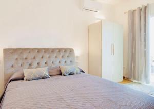 a large bed with two pillows in a bedroom at Casa MILLY in Olbia