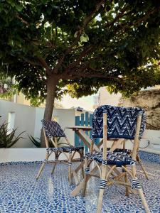 two chairs and a table and a tree on a patio at Oikies Skiathos in Skiathos +43 photos