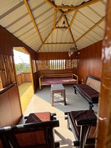 an inside view of a room with benches and tables at Peepal in Aranyaa Cottage Homestay Vrindavan in Vrindāvan