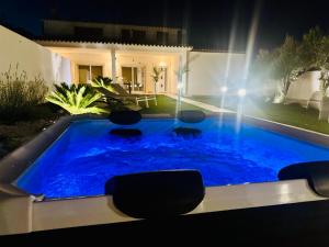 a swimming pool in the backyard of a house at night at Casa MILLY in Olbia