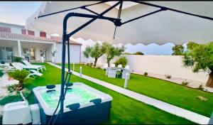 a backyard with a hot tub and an umbrella at Casa MILLY in Olbia +24 photos