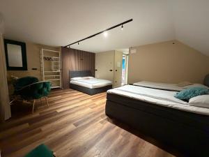 a bedroom with two beds and a chair in it at Boutique hotel ZBILJE in Zbilje
