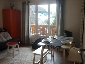 een woonkamer met een tafel en een groot raam bij Les Myosotis in Les Deux Alpes