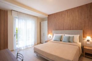a bedroom with a large bed and a large window at Residence Elisabetta in Cesenatico
