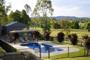 a fence around a swimming pool in a yard at Riverbend Ranch Tamborine in Tamborine