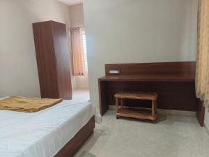 a bedroom with a bed and a wooden desk at Nayana comforts in Nandigunda +14 photos