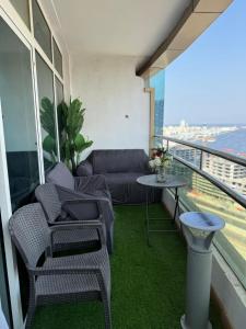 a balcony with a couch and chairs and a table at الهورايزون in Ajman 