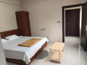 a bedroom with a bed and a chair in it at Nayana comforts in Nandigunda