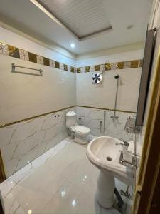a bathroom with a toilet and a sink at Royal swiss Hotel Khanpur in Khānpur