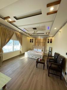 a bedroom with a bed and a couch and a chair at Royal swiss Hotel Khanpur in Khānpur