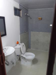 a bathroom with a white toilet and a sink at Apart Cabaña KTIK in San Bernardo del Viento +41 photos