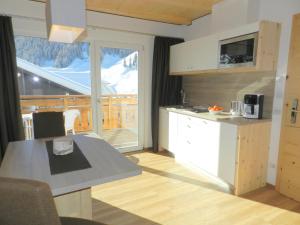 a kitchen with a table and a counter top at Garni Hotel Mezdi in Selva di Val Gardena
