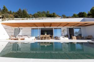 a villa with a swimming pool in front of a house at Amore Luxury Villas Resort in Athani