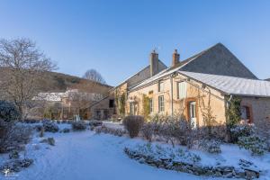 an old house with snow on the ground at Maison de vacances Les Mésanges, à Ménessaire in Ménessaire