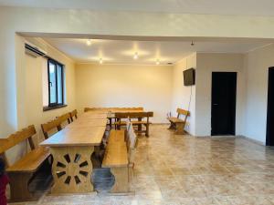 a large dining room with wooden tables and chairs at Къща за гости Sunrise - Батак in Batak