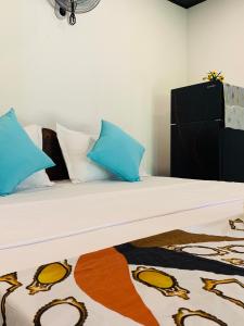 a bedroom with a bed with blue and white pillows at D2 Villa in Tangalle