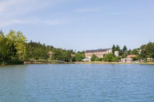 a view of a lake with buildings in the background at Hotel Miramonti in Bagno di Romagna