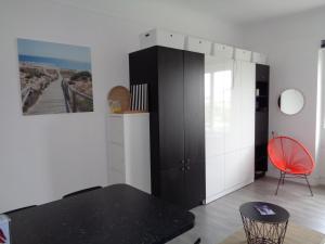 a room with a black cabinet and a red chair at Studio Privé Résidence Regina in Biarritz