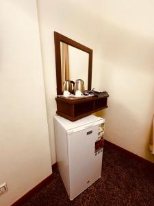 a mirror on top of a refrigerator in a room at فندق أوفوك كيندا - ofok kenda hotel in Az Zahrāʼ