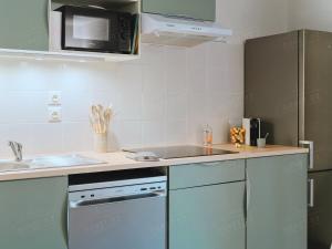 a kitchen with a sink and a stove top oven at Maison de vacances près du Mont Ventoux in Aubignan